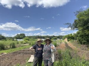 Farmers Suna Turgay and Stacia Potter of Northampton's Flowerwork Farm clean up their lot after the flooding.